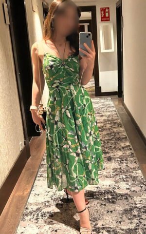 Cristina Godoy, escort madrid, caminando por un pasillo con vestido verde