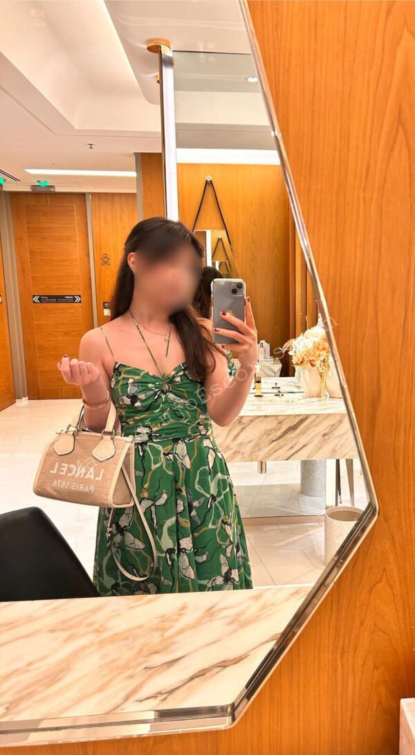Cristina Godoy con vestido verde reflejada en el espejo