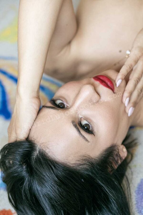 Retrato de Emma, escort en Madrid con labios rojos y mirada seductora.