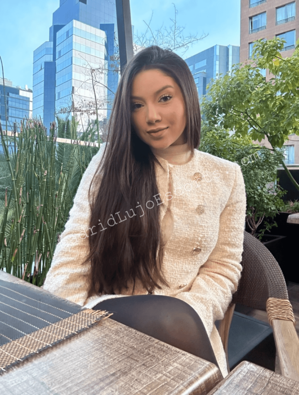 Amandinha sentada en terraza con conjunto blanco
