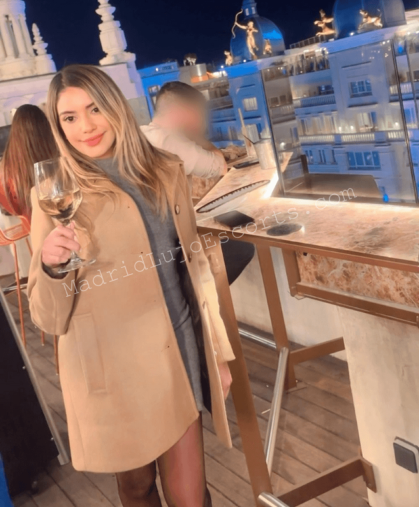 Lilian con copa de vino en terraza iluminada de noche