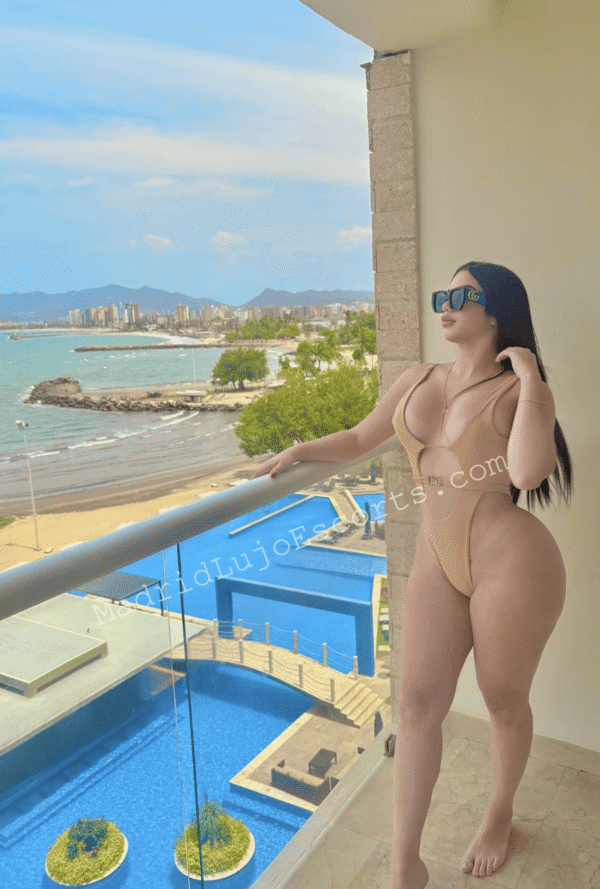 Nahomy en bikini claro, en terraza de hotel frente al mar