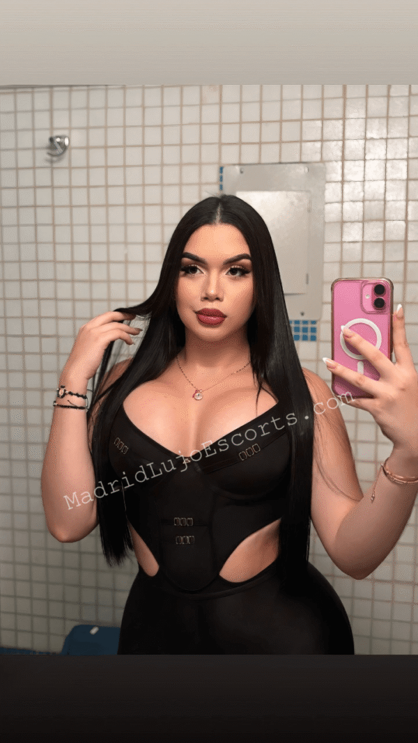Nahomy con conjunto negro ajustado, selfie frente al espejo