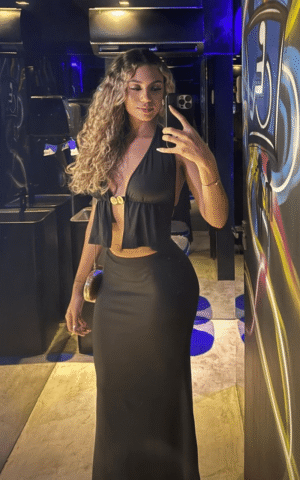 Aurora escort brasileña de lujo en Madrid con vestido negro ceñido en ambiente nocturno