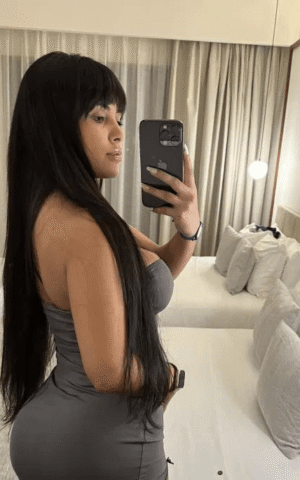Fernanda escort brasileña de lujo en Madrid con vestido gris ajustado marcando curvas