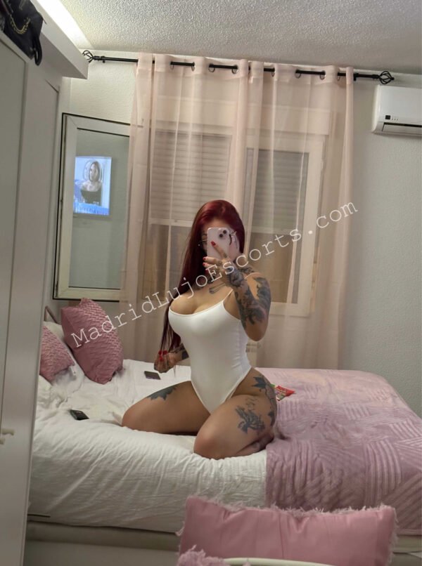 Nicol con body blanco ajustado, selfie en la habitación