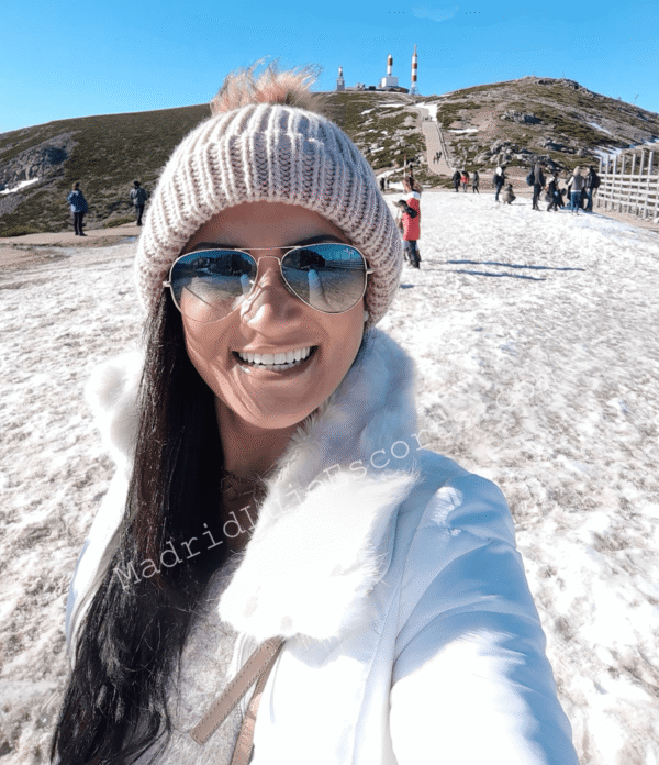Victoria en la nieve con gorro y gafas, sonriendo