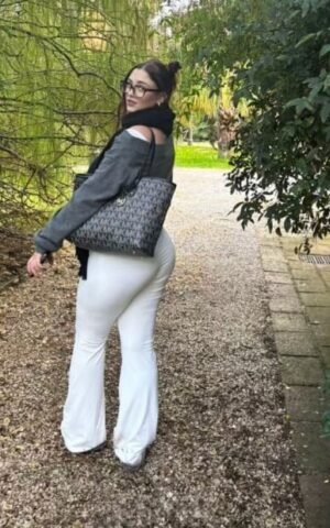 Martina escort española de lujo en Maadrid caminando por el parque con pantalón blanco ajustado