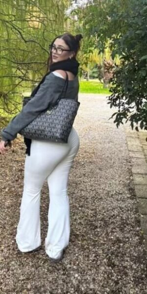 Martina escort española de lujo en Maadrid caminando por el parque con pantalón blanco ajustado