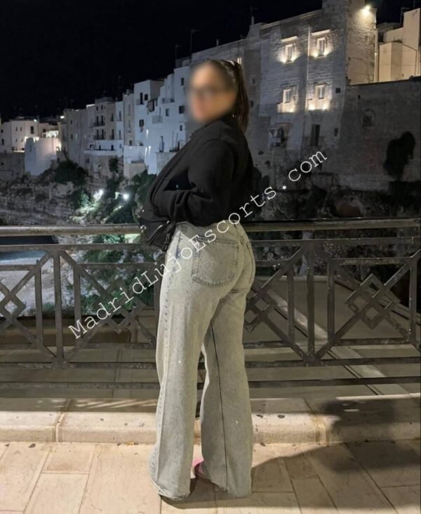 Belén contemplando la ciudad de noche con pantalones claros