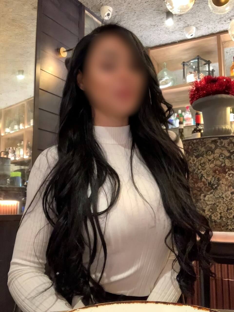 Elektra, escort madrid con top blanco en un bar