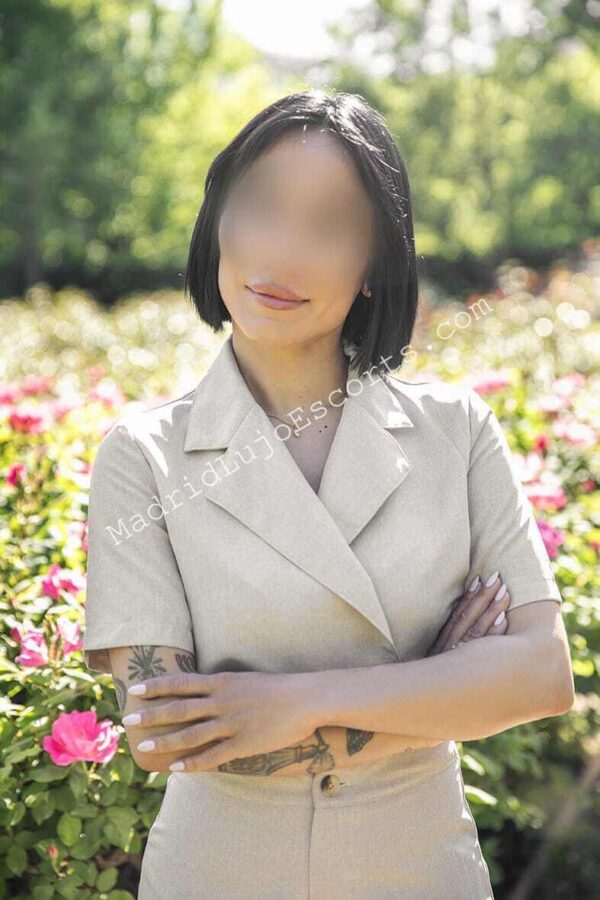 Emma escort española en Madrid con conjunto beige en un jardín
