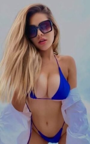 Nick, escort madrid con gafas de sol y bikini azul mirando a cámara