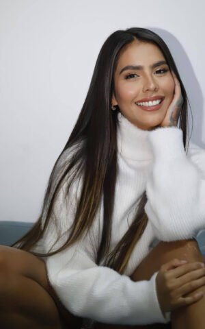 Nastassia escort venezolana de lujo en Madrid con suéter blanco y sonrisa encantadora