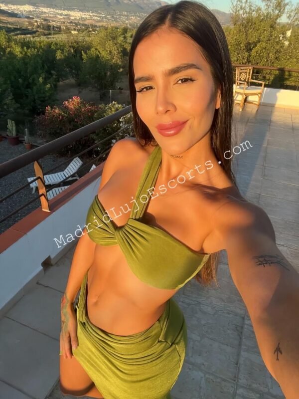 Nastassia escort venezolana en Madrid en bikini verde sobre una terraza soleada