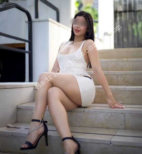 Gabriela escort venezolana en Madrid posando con vestido blanco en escaleras