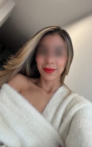 Lucie, escort Madrid sacándose un selfie con bata blanca