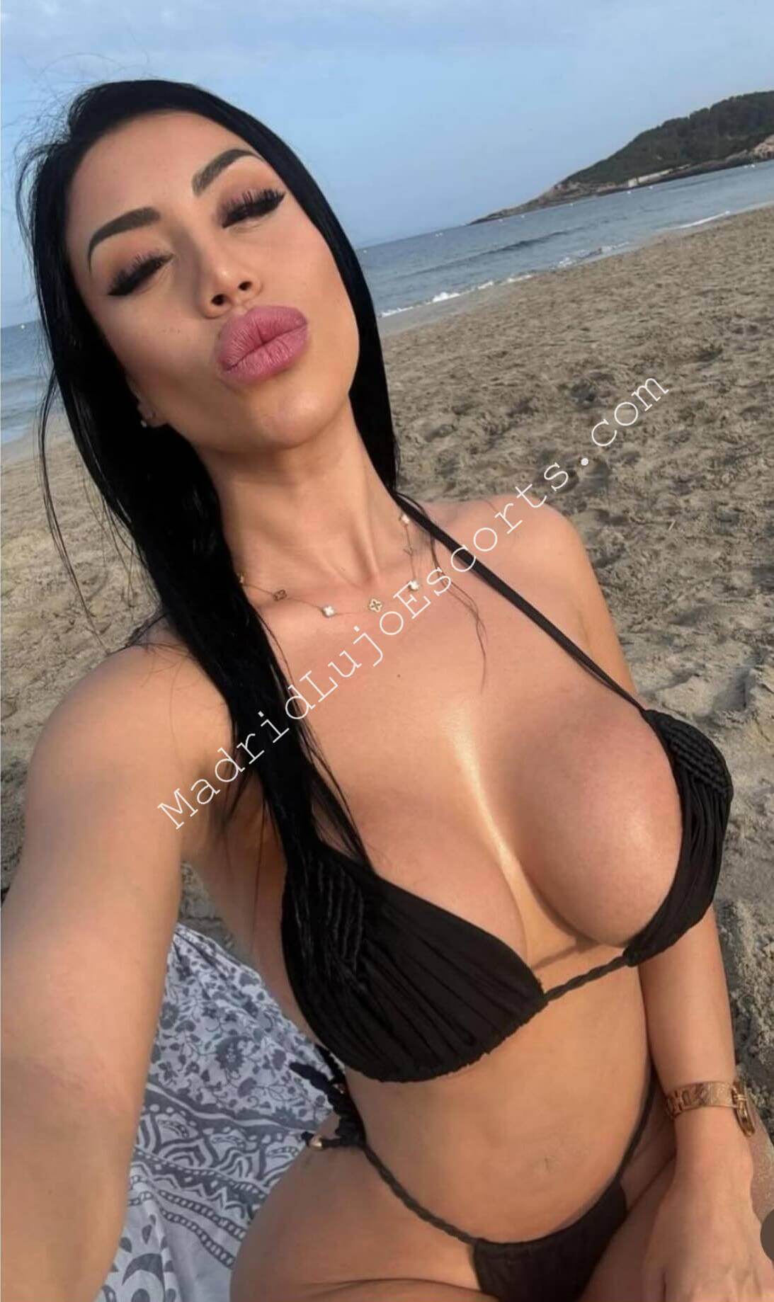 Brendi escort Madrid sacándose un selfie en la playa con bikini