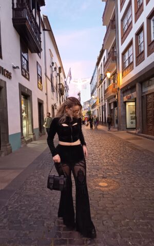 Lia, escort Madrid caminando por una calle urbana con outfit negro