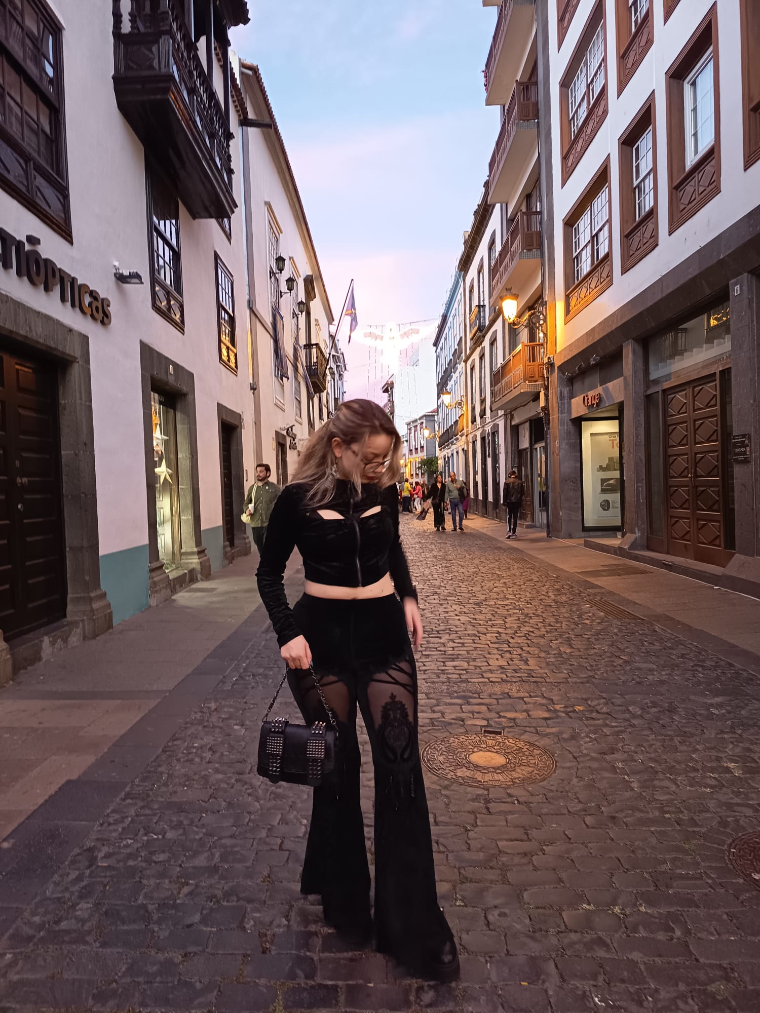 Lia, escort Madrid caminando por una calle urbana con outfit negro