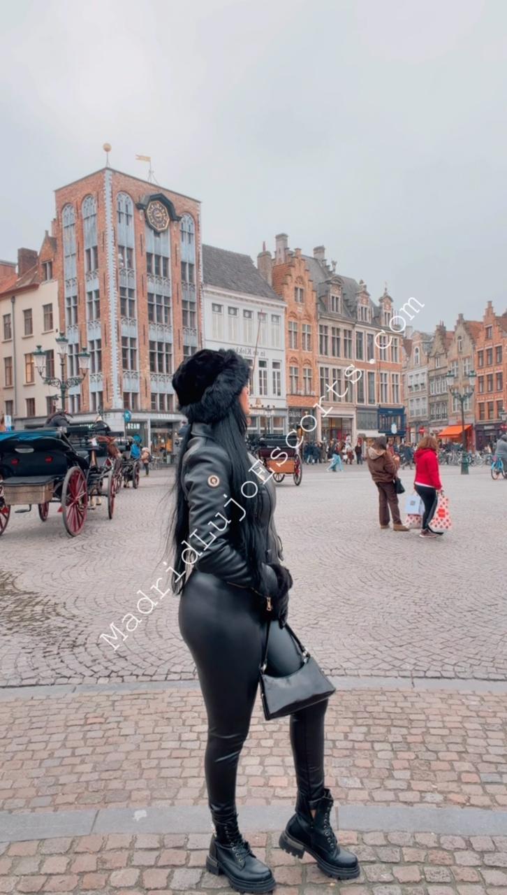 Aline escort brasileña en Madrid posando en entorno urbano con look negro