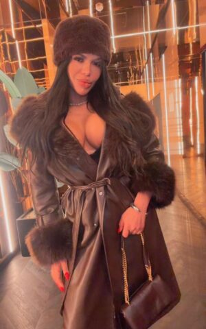 Vick, escort Madrid posando en exterior nocturno con abrigo oscuro