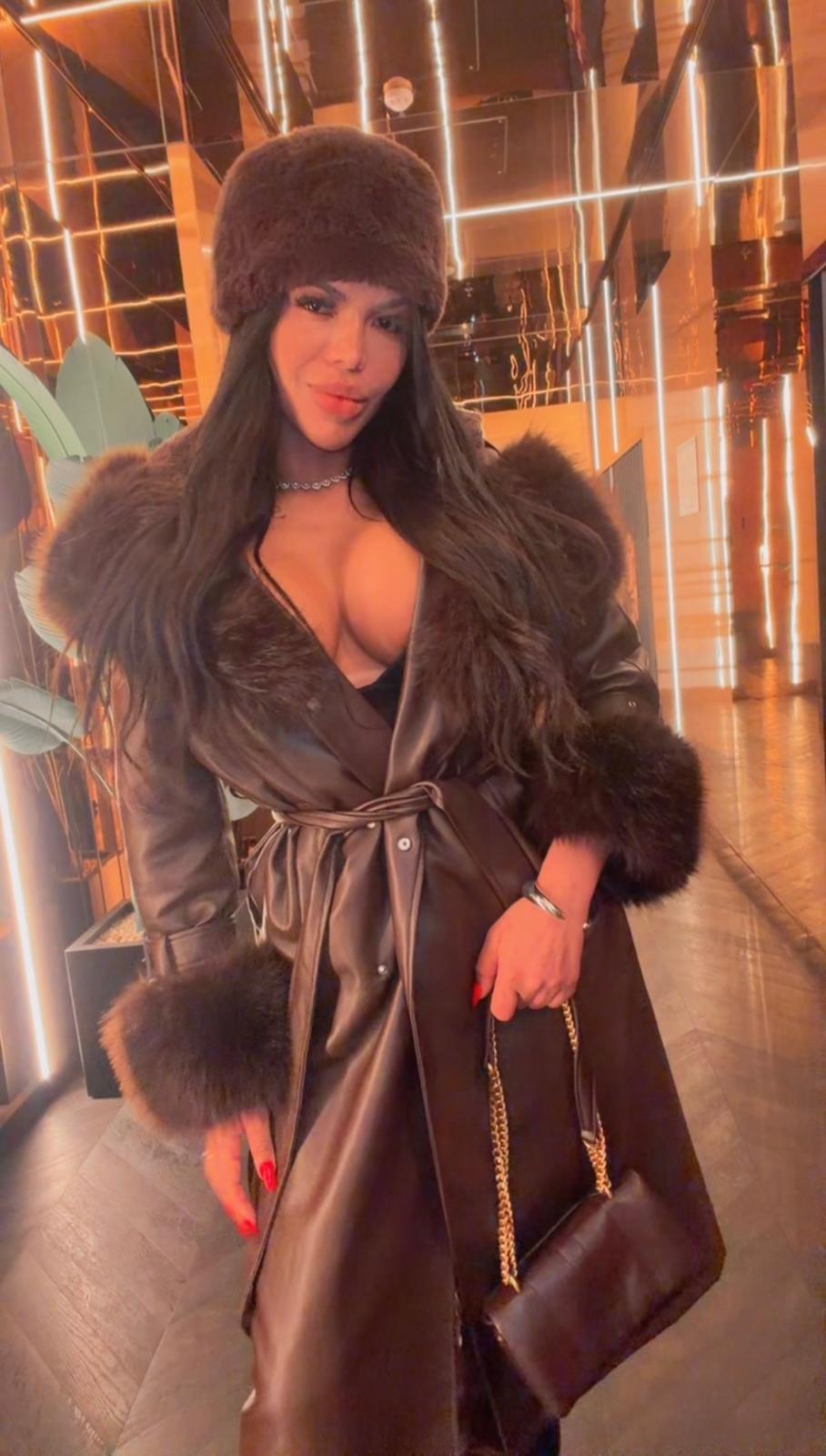 Vick, escort Madrid posando en exterior nocturno con abrigo oscuro