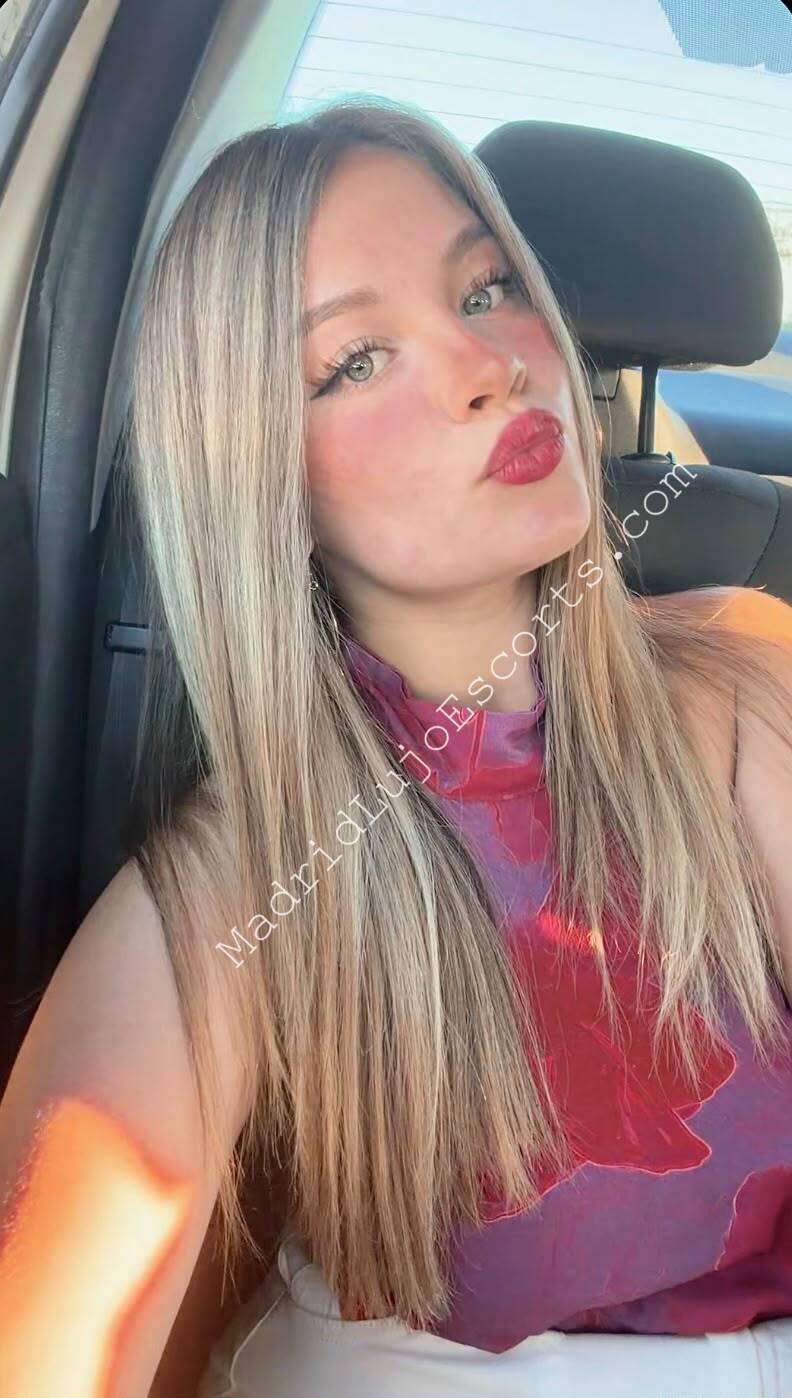 Mia escort venezolana en Madrid posando en un coche con iluminación natural