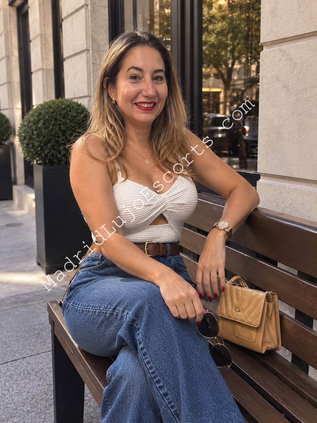 Paty escort brasileña en Madrid sentada en un banco con look casual